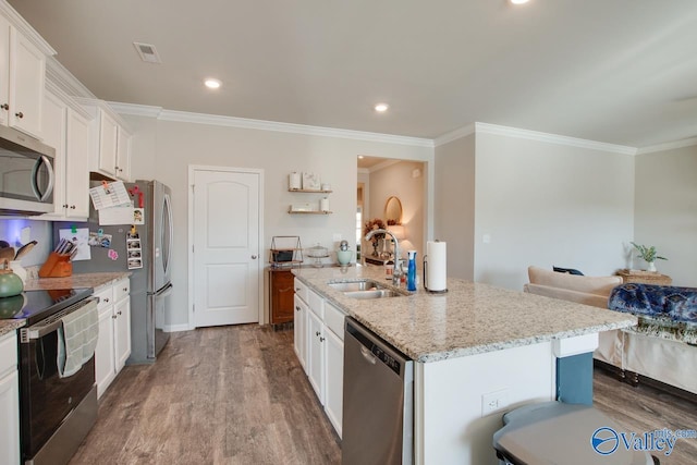 kitchen with white cabinets, stainless steel appliances, and an island with sink