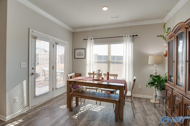 dining space featuring hardwood / wood-style floors and crown molding