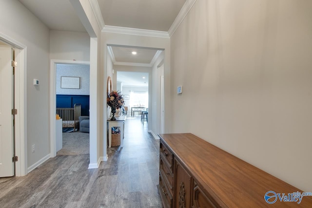 hallway featuring ornamental molding and light wood-type flooring