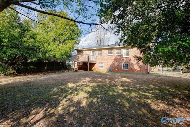 back of property with a wooden deck and a yard