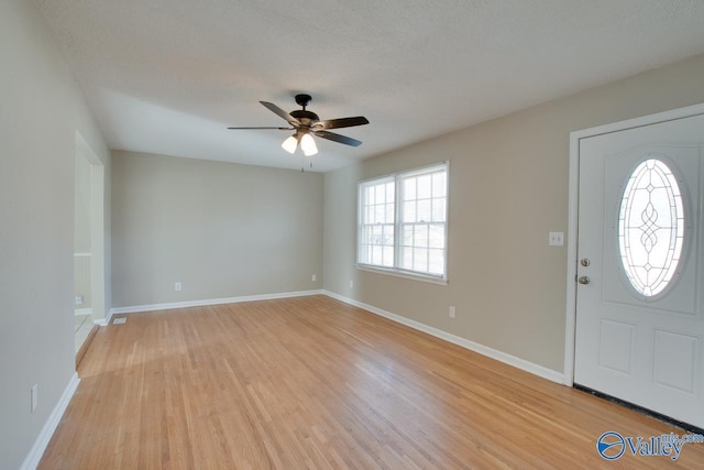 entrance foyer with a textured ceiling, light hardwood / wood-style floors, and ceiling fan