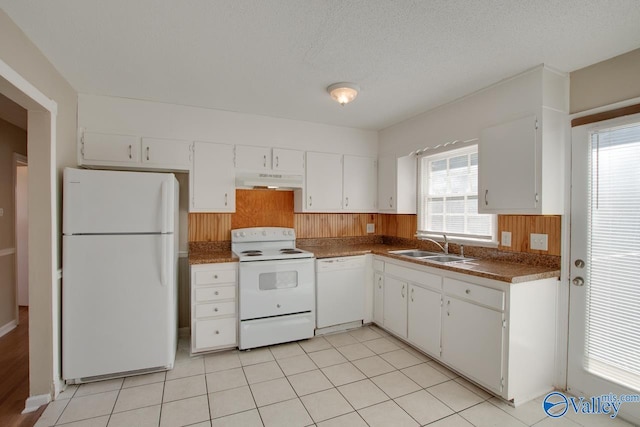 kitchen featuring white appliances, sink, light tile patterned floors, a textured ceiling, and white cabinetry