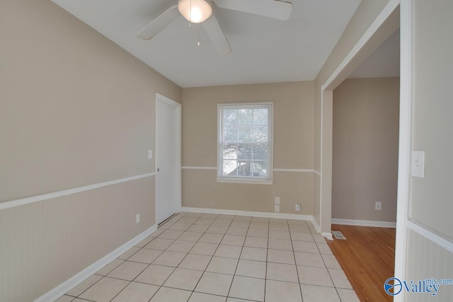 empty room with ceiling fan and light hardwood / wood-style flooring