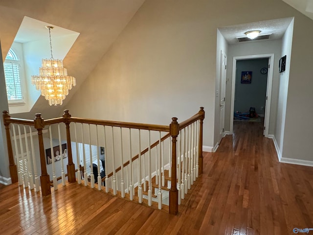 interior space with an inviting chandelier, lofted ceiling, and hardwood / wood-style floors