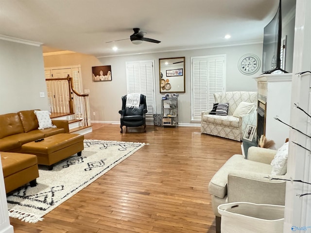 living room with ceiling fan, hardwood / wood-style flooring, and ornamental molding