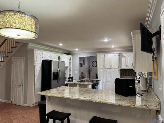 kitchen featuring white cabinets, hanging light fixtures, crown molding, and stainless steel fridge with ice dispenser