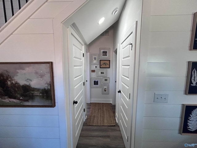 corridor with dark hardwood / wood-style flooring and lofted ceiling