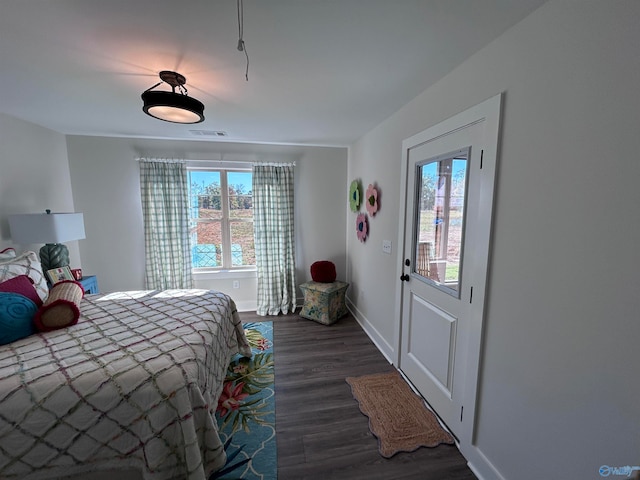 bedroom with multiple windows and dark hardwood / wood-style flooring