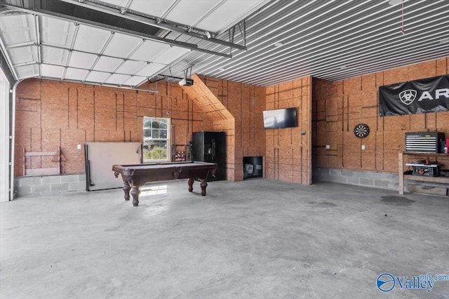 2403 Hog Jaw Rd, Arab, AL 35016 - garage with black fridge with ice dispenser, concrete block wall, and a garage door opener