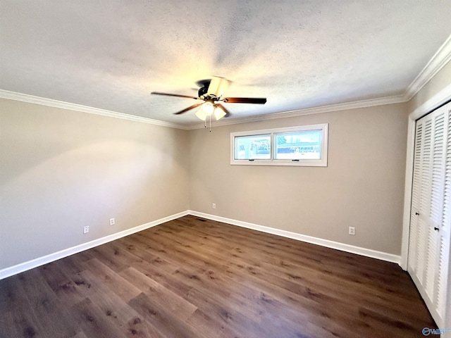 unfurnished bedroom featuring baseboards, dark wood finished floors, ornamental molding, a textured ceiling, and a closet