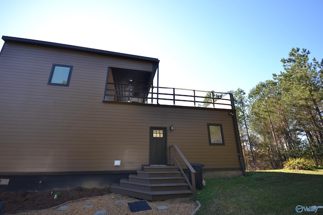 back of property featuring a lawn and a balcony