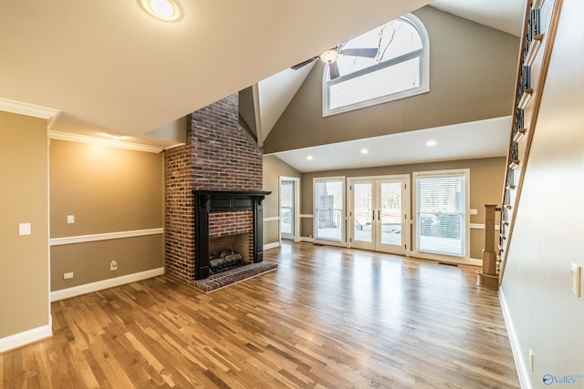 unfurnished living room with crown molding, high vaulted ceiling, light hardwood / wood-style floors, and a brick fireplace