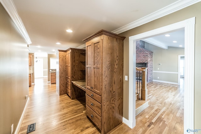 corridor featuring crown molding and light hardwood / wood-style flooring