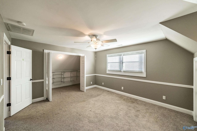 unfurnished bedroom with ceiling fan, light colored carpet, and vaulted ceiling