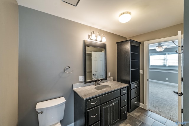 bathroom with tile patterned flooring, vanity, toilet, and ceiling fan