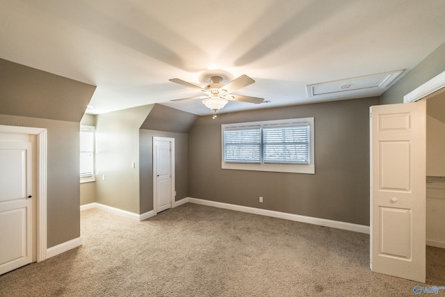 additional living space featuring a healthy amount of sunlight, ceiling fan, light colored carpet, and vaulted ceiling