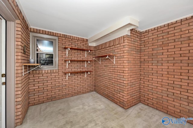 carpeted spare room with brick wall and ornamental molding