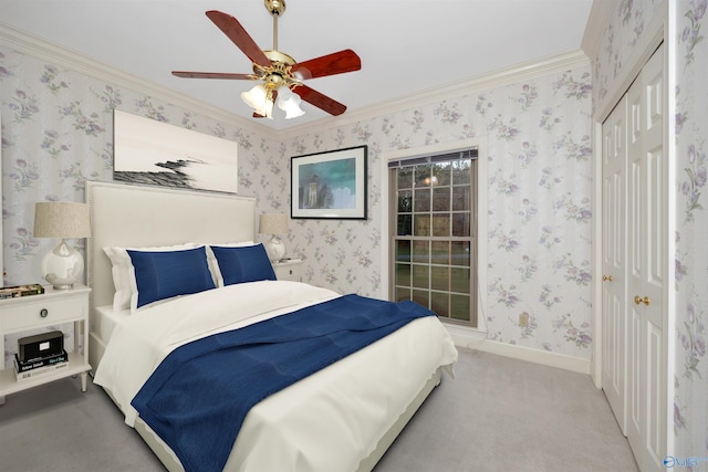 carpeted bedroom featuring a closet, crown molding, and ceiling fan