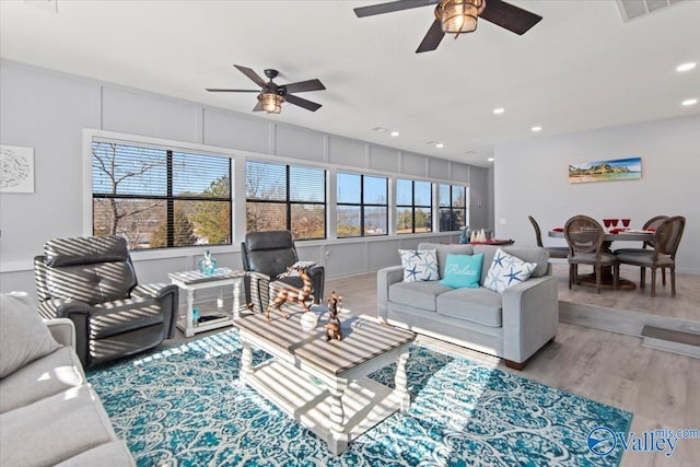 living room featuring ceiling fan and hardwood / wood-style flooring