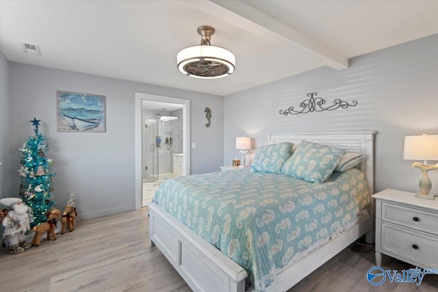 bedroom featuring beamed ceiling, ensuite bathroom, and light hardwood / wood-style floors