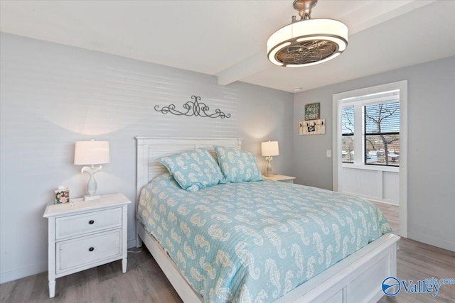 bedroom with hardwood / wood-style flooring and beamed ceiling