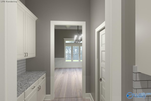 corridor featuring a wainscoted wall, light wood-style flooring, and a decorative wall