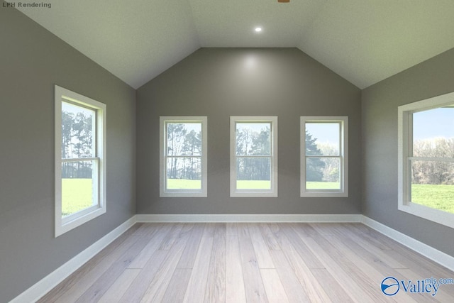 empty room with vaulted ceiling, baseboards, and light wood-type flooring