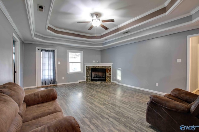 living room with a raised ceiling, ceiling fan, crown molding, hardwood / wood-style flooring, and a fireplace