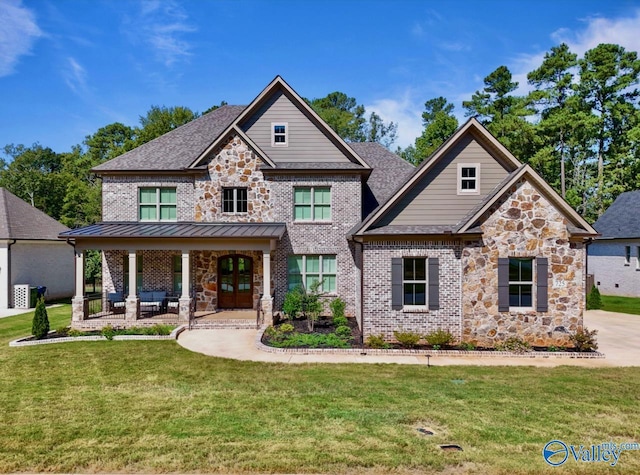 craftsman-style home featuring a front lawn, a standing seam roof, french doors, metal roof, and brick siding