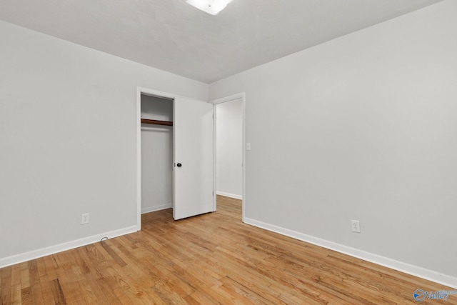 unfurnished bedroom with a closet and light hardwood / wood-style floors