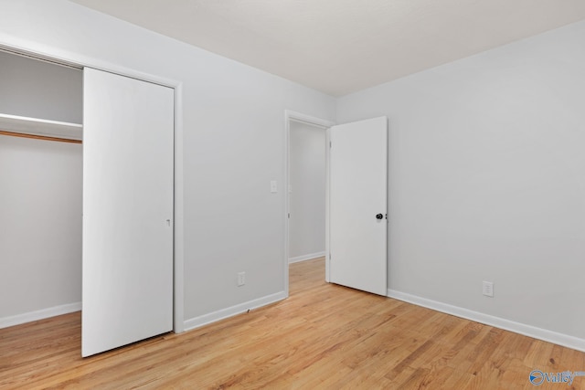 unfurnished bedroom featuring light wood-type flooring and a closet