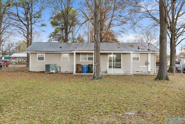 rear view of house with a lawn and central AC