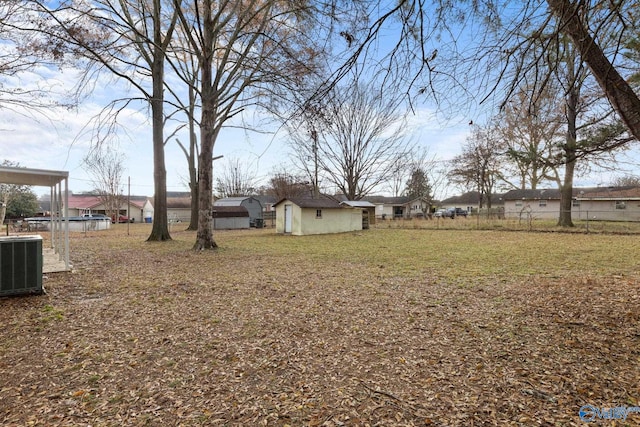 view of yard featuring central AC and a storage unit