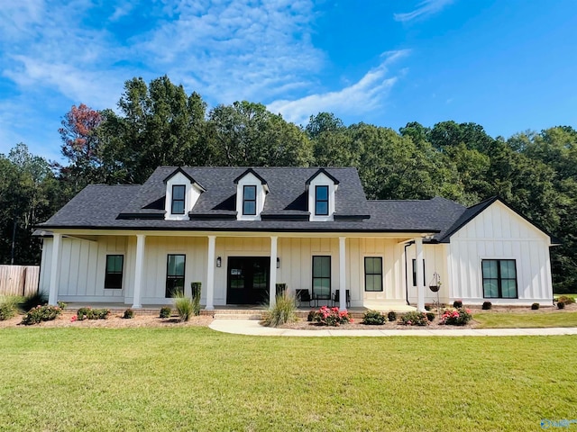 modern farmhouse featuring covered porch and a front yard