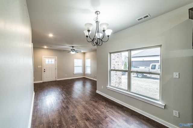 unfurnished room featuring dark wood-type flooring and ceiling fan with notable chandelier