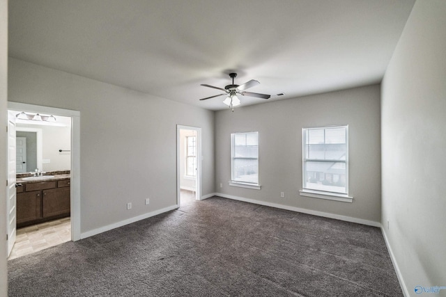 empty room with ceiling fan, sink, and carpet