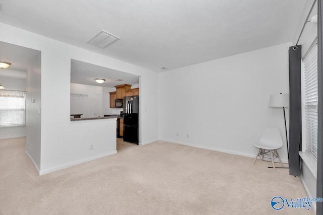 unfurnished living room featuring light carpet