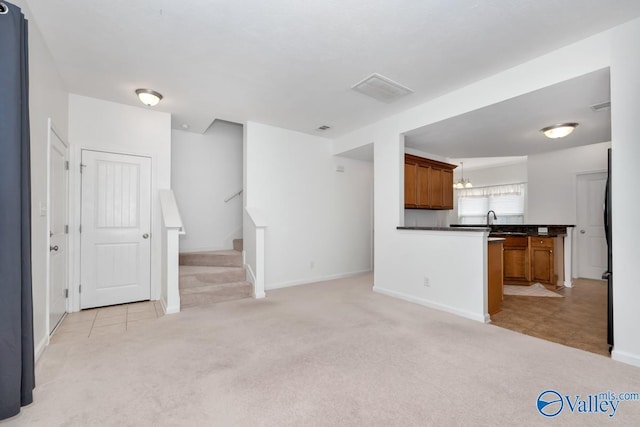 unfurnished living room with sink and light carpet