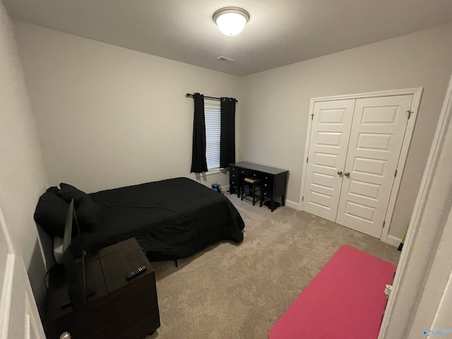 bedroom featuring light carpet and a closet