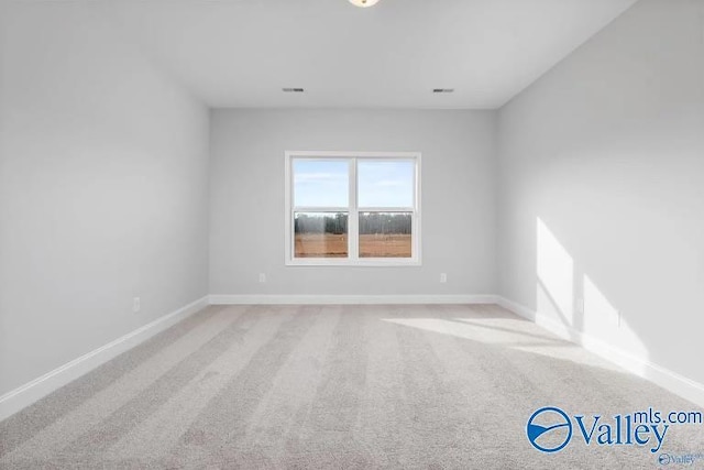 spare room featuring light colored carpet