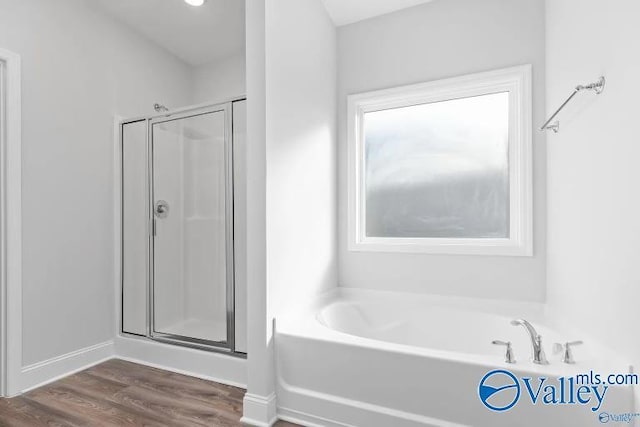 bathroom with independent shower and bath and hardwood / wood-style floors