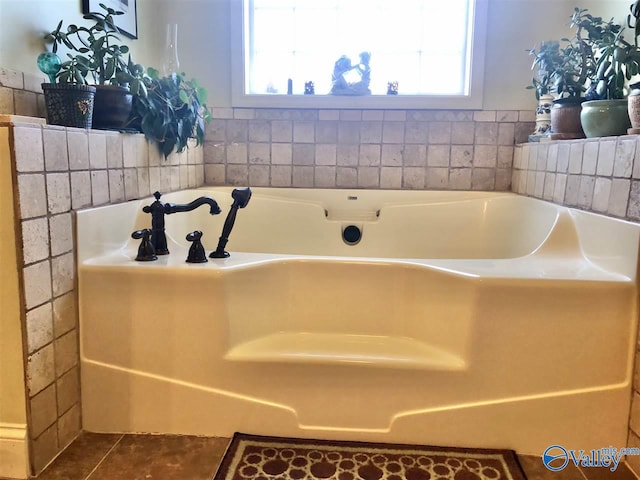 bathroom featuring tile patterned floors, a wealth of natural light, and a bathtub