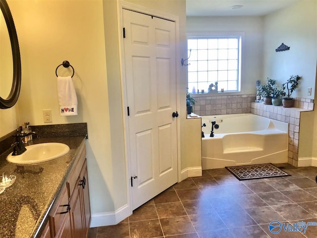 bathroom featuring tile patterned floors, a bathing tub, and vanity