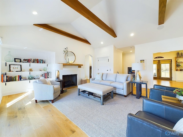 living room featuring beamed ceiling, light hardwood / wood-style floors, and high vaulted ceiling