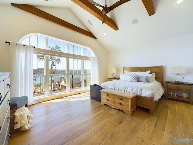 bedroom with beamed ceiling, a water view, light wood-type flooring, and high vaulted ceiling