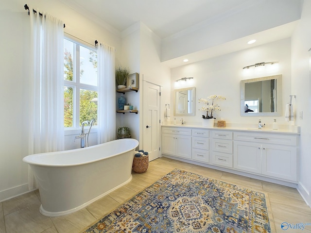 bathroom featuring plenty of natural light, vanity, ornamental molding, and a washtub