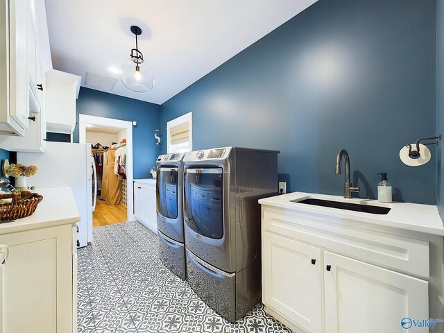 clothes washing area featuring washer and dryer, sink, and light hardwood / wood-style flooring