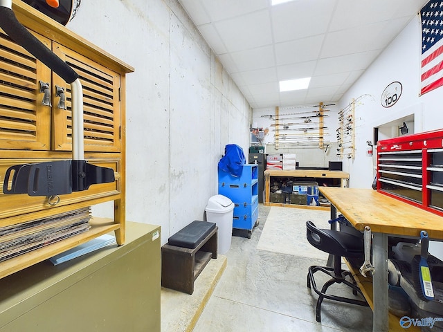 interior space with a workshop area, a drop ceiling, and concrete floors