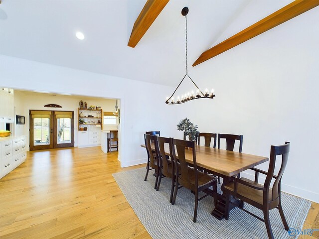 dining space featuring french doors, lofted ceiling with beams, light hardwood / wood-style floors, and an inviting chandelier