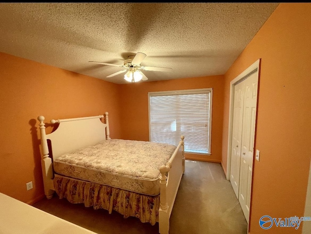 bedroom featuring a ceiling fan, dark colored carpet, and a textured ceiling